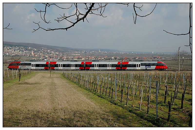 Ein Zweisystemtalent der Reihe 4124 als REX 2821 „Lverek“ von Wien Sdbahnhof ber Ebenfurth nach Deutschkreuz am 10.3.2007. Im Hintergrund von links nach rechts am Fue des Leithagebirges zu sehen: Grohflein, Kleinhflein, und ganz links die Landeshauptstadt des Burgenlandes, Eisenstadt.  