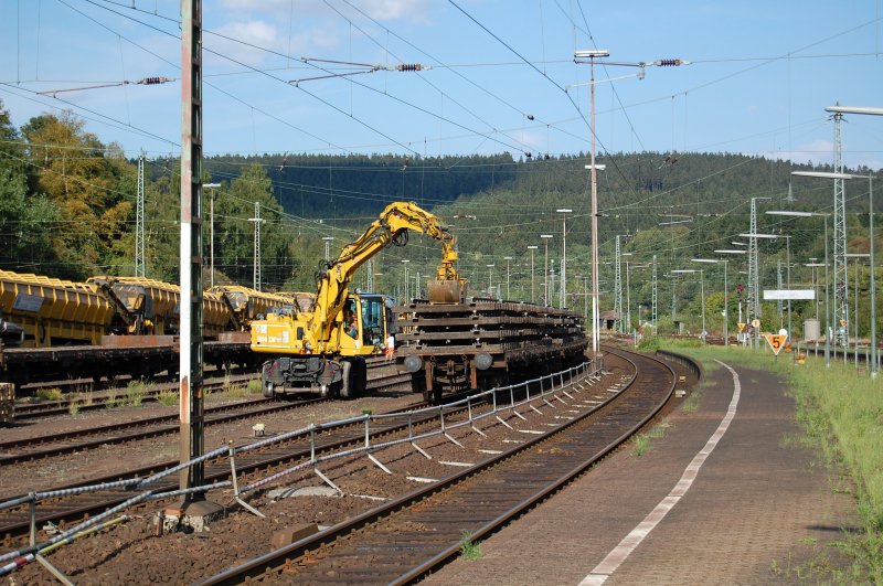 Ein Zweiwegbagger entlud am 26.08.09 einen mit alten Schienenteilen beladenen Rungenwagenzug im Bahnhof Altenbeken.