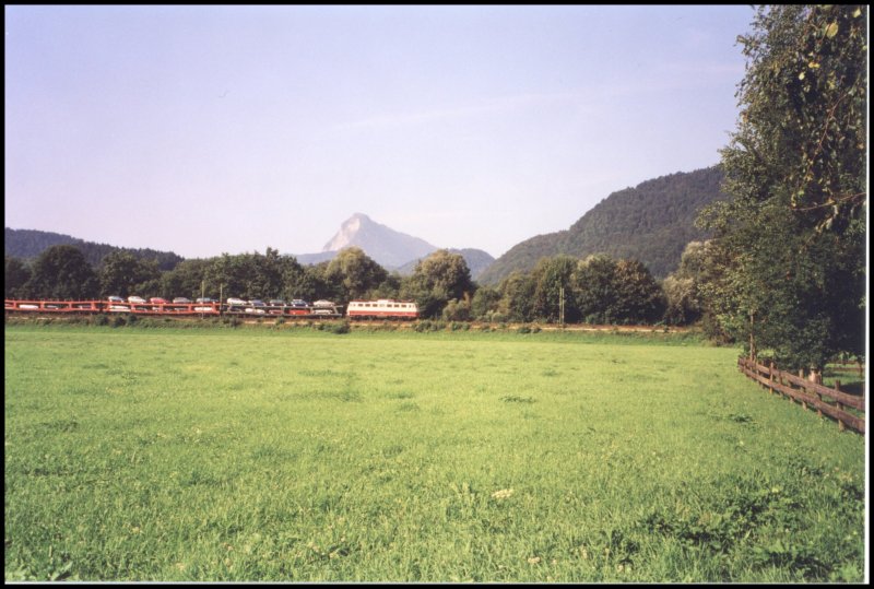 Eine 113 bringt einen Autoreisezug aus sterreich richtung Mnchen. Hinter der Lok luft ein grner Autotransportwagen mit. Aufgenommen im Sommer 2003 zwischen Kiefersfelden und Oberaudorf.