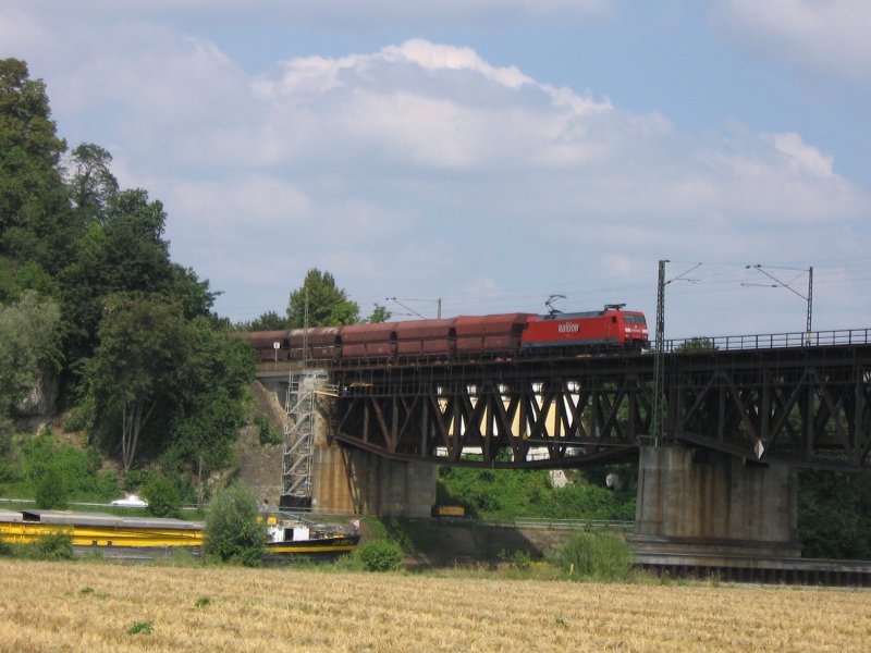Eine 152 berquert mit einem Gterzug am 4.8.2007 die Donaubrcke in Regensburg. Auf der Donau fhrt gerade ein Schiff.