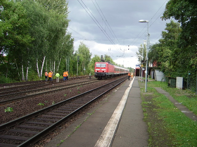 Eine BR 143 mit der RB 55 in Maintal Ost. An der linken Seite wird die Ausfahrt von Gleis 3 von Bahnmitarbeitern geprft. 