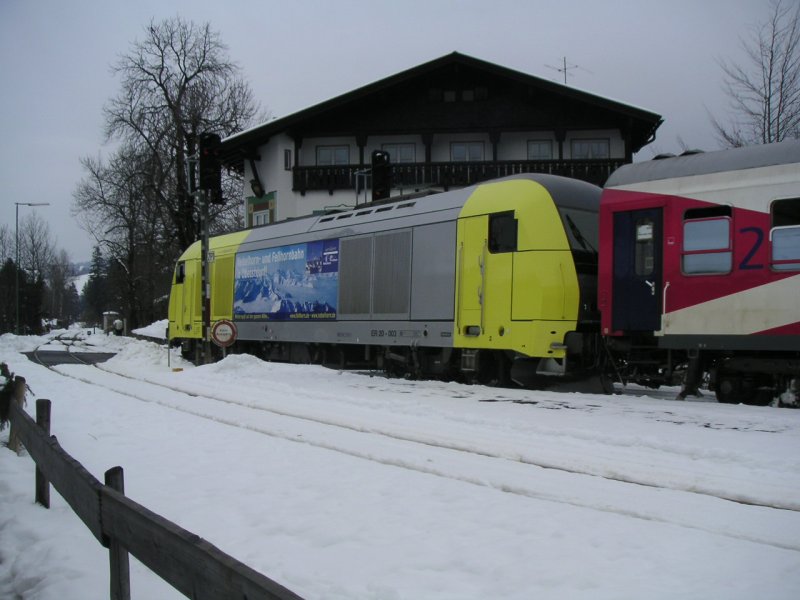 Eine  Dispolok  ER 20 zieht ihren ALX bei tiefem Schnee aus dem kleinen Bahnhof Fischen nach Mnchen Hbf. Aufgenommen am 12.02.04