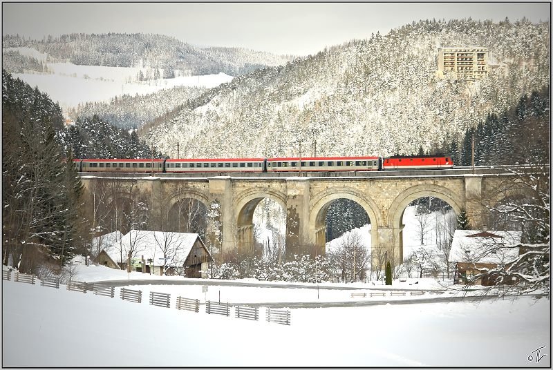 Eine E-Lok der BR 1144 fhrt mit EC 733  Der Warmbadnerhof  von Wien nach Villach.Hier berquert der Zug das Adlitzgraben Viadukt am Semmering. 21.03.2009