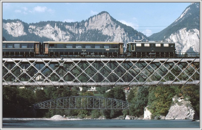 Eine Ge 4/4 I im ursprnglichen grnen Farbkleid fhrt ber die Hinterrheinbrcke bei Reichenau-Tamins. Die Stahlbogenbrcke der Strasse Bonaduz-Tamins im Hintergrund ist in der Zwischenzeit auch durch eine weniger schne Betonbrcke ersetzt worden. (Archiv 09/78)