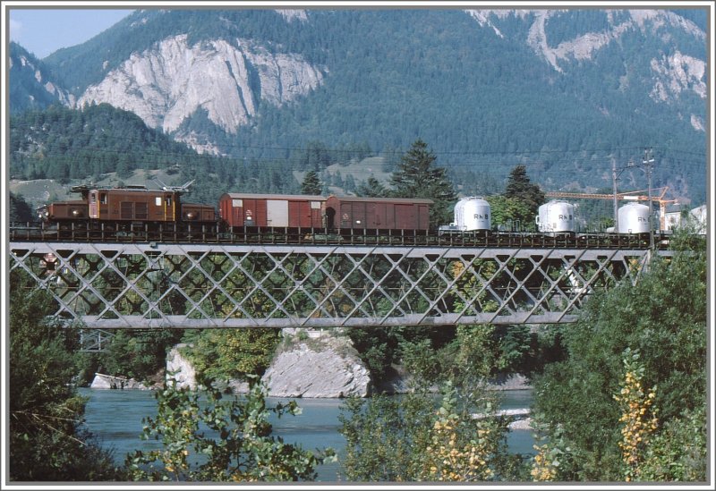Eine Ge 6/6 I Krokodil berquert den Hinterrhein bei Reichenau-Tamins mit einem Gterzug mit offensichtlich neuen Zementsilowagen. (Archiv 09/78)