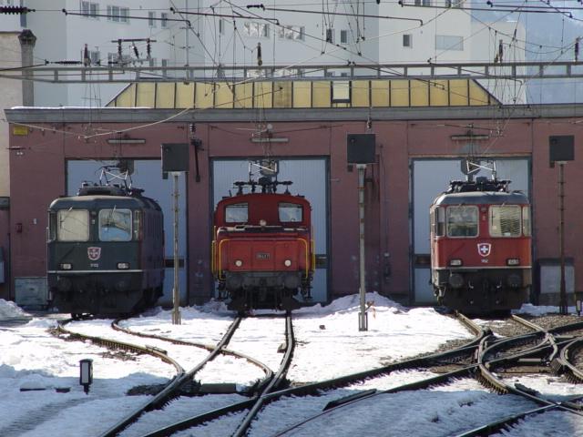 eine grne Re 4/4 II und eine rote Re 4/4 II dazwischen eine Ee 3/3 abgestellt vor dem Depot Chur am 23.02.03 in Chur 