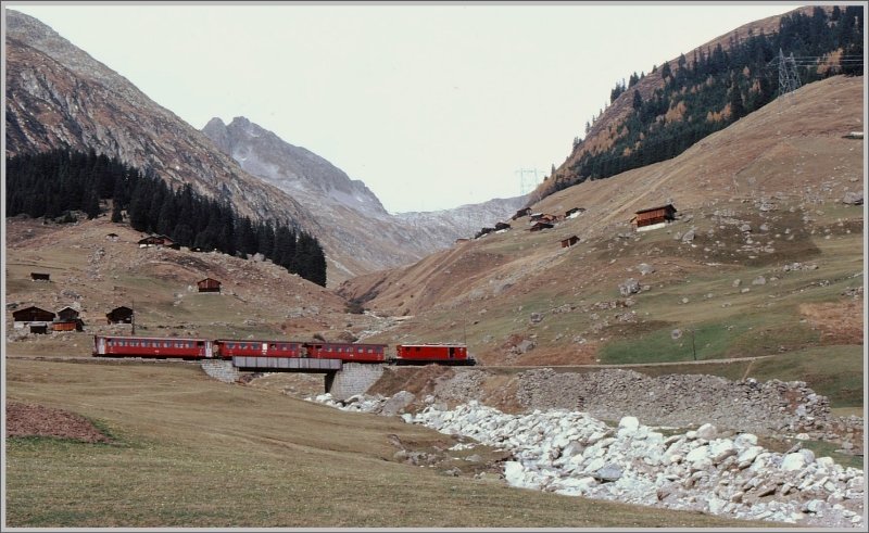 Eine HGe 4/4 I der FO fhrt mit einem Regio bei Rueras Richtung Sedrun. Zwei der drei Personenwagen verfgen noch ber offene Plattformen. (Archiv 11/77)