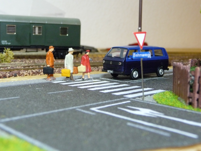 Eine kleine Gruppe reisender berquert den Schutzweg, whrend der Fahrer des VW T3 warten muss. Im Hintergrund ist ein zweiachsiger Gepckwagen der BB abgestellt. (10.08.09)