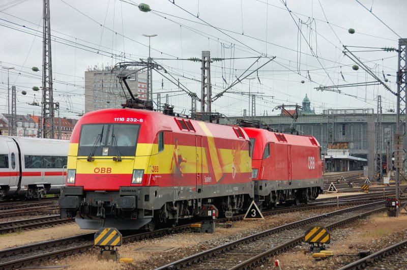 Eine Kollegin in Schlepp genommen: 1116 232-8  Spanien  und eine rote 1016 beziehen ihre Warteposition im Mnchner Vorfeld. 16.06.2008 zur Mittagszeit.