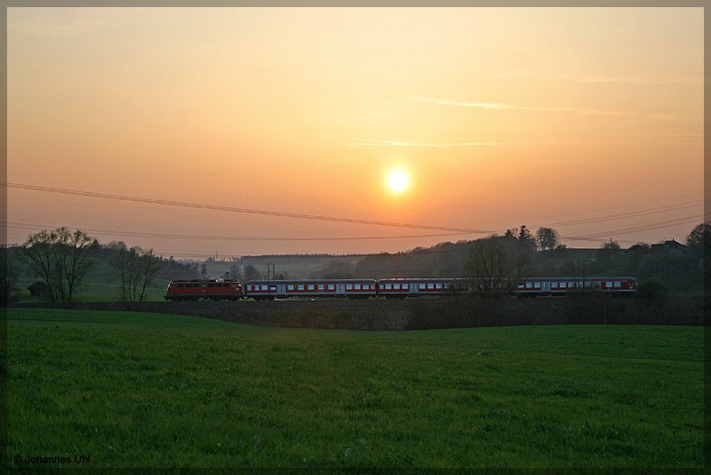 Eine Lok der Baureihe 110 schob am Abend des 10.04.2009 eine RB von Aalen nach Donauw�rth und bekam dabei zwischen Aalen-Oberalfingen und Goldsh�fe die letzte W�rme der langsam im Dunst versinkenden Sonne ab.