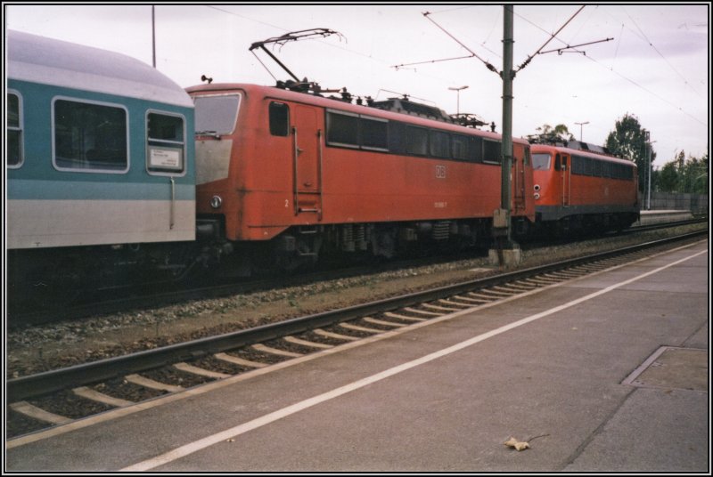 Eine Orientrote 111 und eine 110 warten gemeinsam am Zugschluss einer Regionalbahn auf die Weiterfahrt nach Rosenheim. Aufgenommen im Sommer 2000 im Bahnhof Kiefersfelden.
