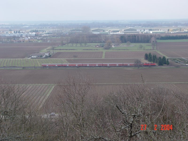 Eine RB gezogen von einer Bgelfalten-110, befhrt die Rheintalstrecke Richtung Norden, von Lahr kommend. Im Hintergrund die Hangars des Lahrer Flugplatzes (ehemalige kandadische Airbase). Aufgenommen am 27.2.2004 vom Schutterlindenberg aus.
