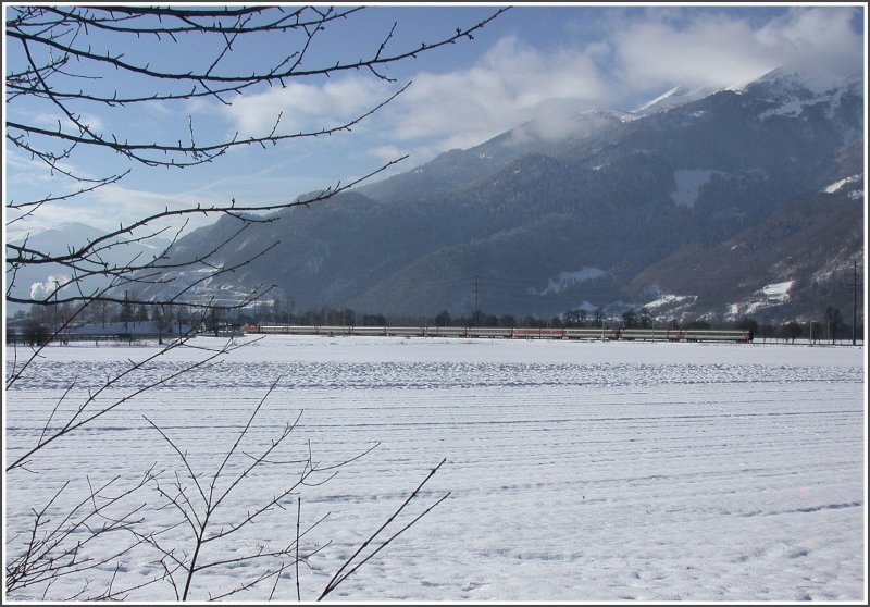 Eine Re 4/4 II eilt mit einem Eurocity am wolkenverhangenen Calanda vorbei Richtung Chur. (29.01.2007)