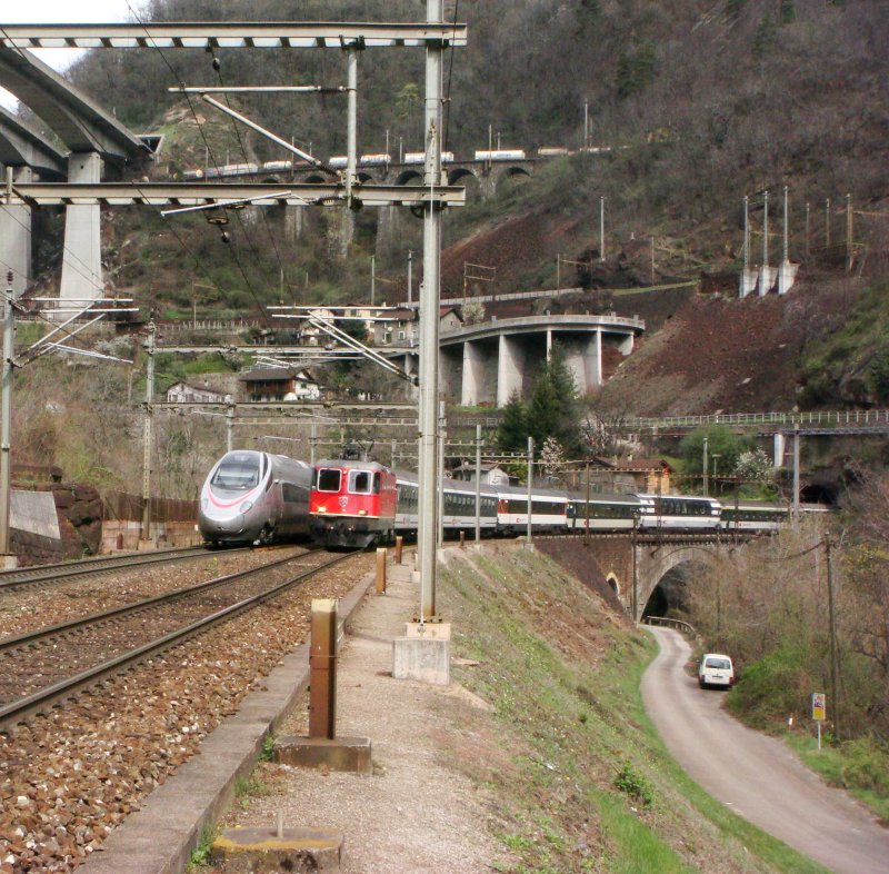 Eine Re 4/4 II mit IR nach Locarno begegnet bei Gironico in der Biaschina dem ETR 610 001 auf Probefahrt am 03.10.2008. Auf der obrersten Ebene sind Fragmente eines Gterzuges zu sehen.