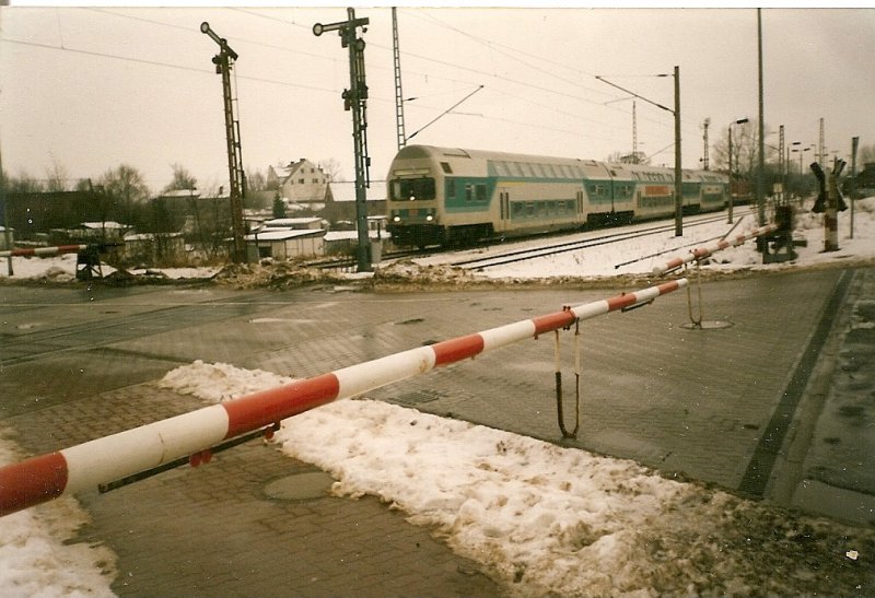 Eine Regionalbahn von Stralsund verlt im Januar 1997 den Bahnhof von Lancken nach Sassnitz.Im Vordergrund die damals noch von Schrankenwrtern bediente Ortsschranke von Lancken.