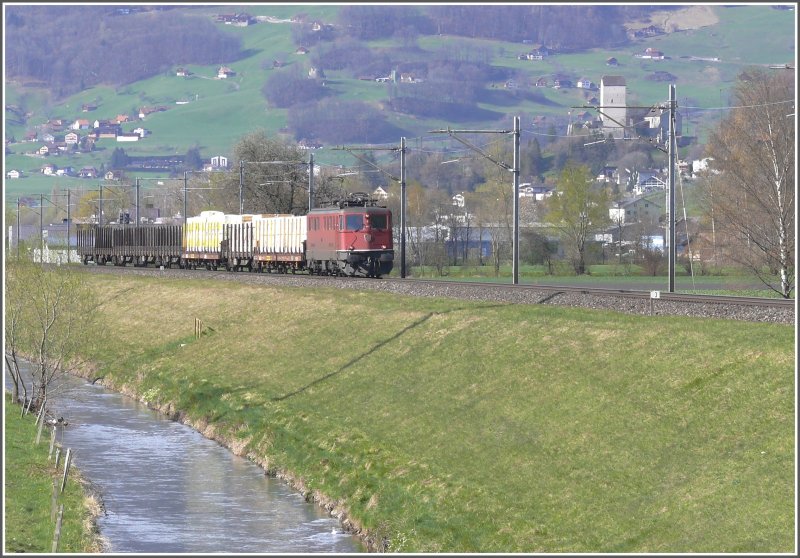 Eine rote Ae 6/6 mit einem  Stallinger Gterzug  aus Ems Werk fhrt dem Binnenkanal entlang zwischen Sargans und Trbbach. Im Hintergrund ist das Schloss Sargans zu sehen. (09.04.2008)