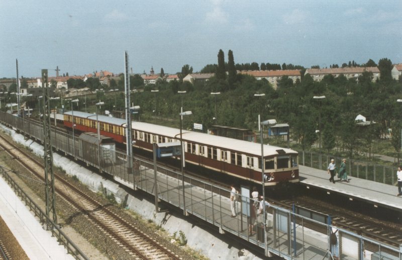 Eine S-Bahn der BR 475, teilweise in DDR-Farbgebung, steht im Jahre 1996 im Bahnhof Bornholmer Strae. Der dortige Behelfsbahnsteig (heute Fernbahngleise) wurde jahrelang fr die S-Bahnen zwischen Schnhauser Allee und Pankow benutzt. Der Umstieg auf die Nord-Sd-Bahn erfolgte ber die Bsebrcke. Heute gibt es hier (links vom Foto) zwei Richtungsbahnsteige.