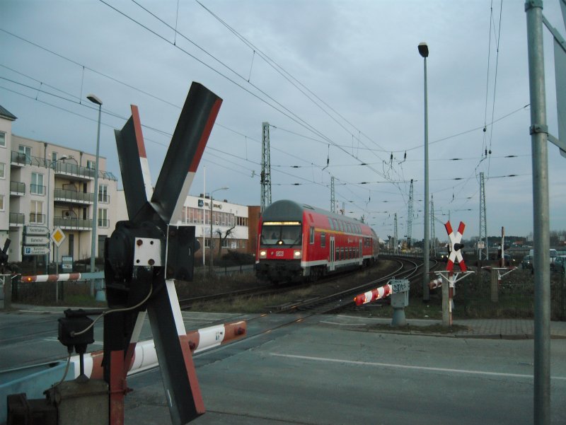 Eine S-Bahn quert die Halbschrankenanlage in Rostock-Warnemnde, die demnchst durch eine Brcke ersetzt werden soll