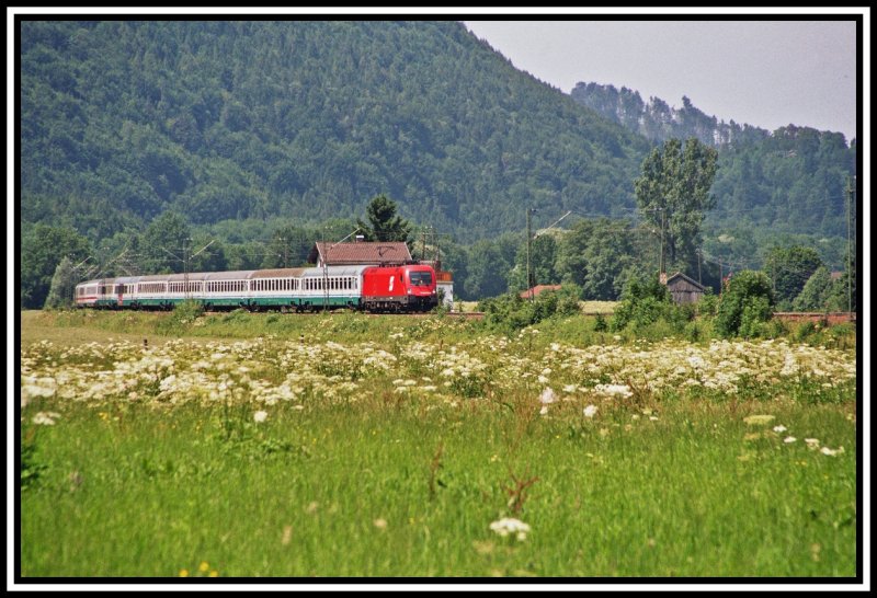 Eine Taurus-Maschine, noch mit altem BB-Logo bringt im Sommer 2005 bei Niederaudorf, den EC89  Leonardo da Vinci  von Mnchen zum Brenner. Die am Zugende eingereihten DB Waggons werden nur im Sommer verwendet.