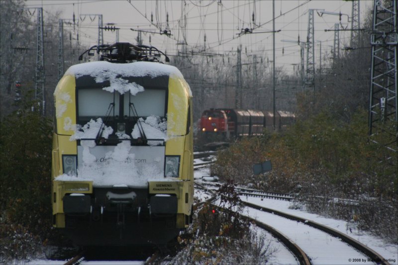 Eine unbekannte ES64U2 der TX Logistik ruht im Schnee whrend 825 der der RBH mit ihren Abraum Zug in den Wanne-Eickler Hbf einfhrt. 24.11.08
