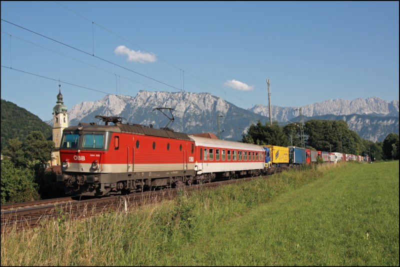 Endlich eine volle RoLa: Die Innsbrucker 1144 225 (9181 1144 225-0) hat am 10.07.2008 den DGS 43842 im Grenzbahnhof Brennero/Brenner von der Trennitalia bernommen und bringt ihn nach Regensburg-Hafen. Im Abendlicht wird der voll ausgelastete Zug vor dem Kaisergebirge abgelichtet. 
