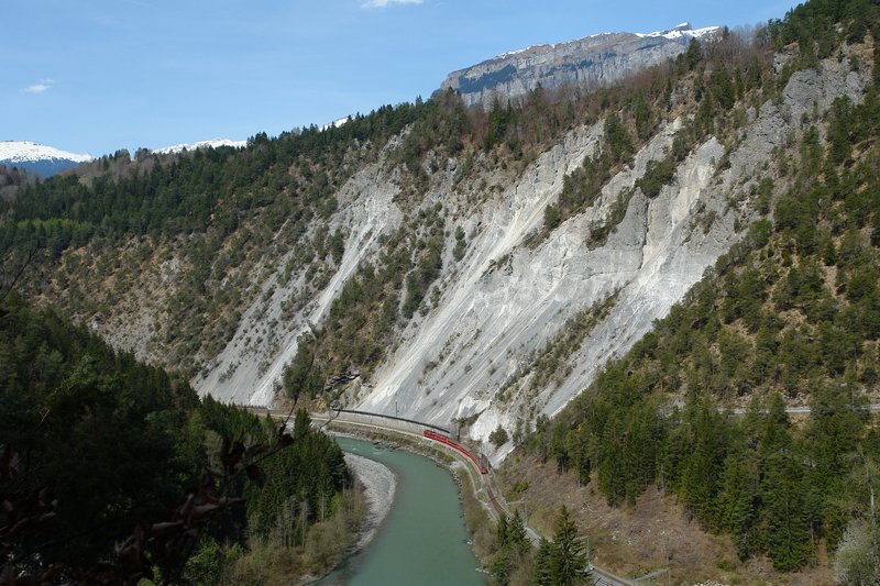 Erst in einer Gesamtaufnahme erkennt man, wie winzig der rote Regionalzug in der gewaltigen Vorderrheinschlucht wirkt. Fr alle Fahrgste sicher eine aufregende Reise durch die Schlucht, hier nach dem Bahnhof Trin in Richtung Disentis. 13.4.2007
