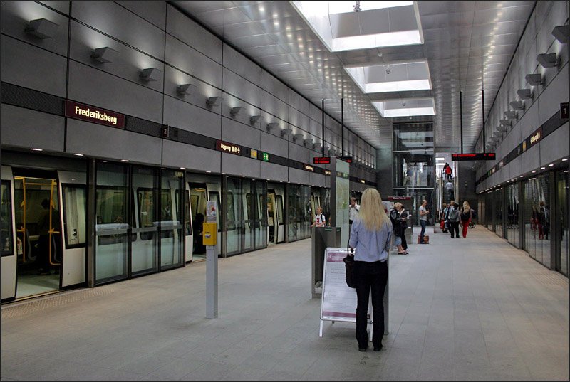 Es gibt in Kopenhagen auch drei Metrostationen, die nicht ganz so tief liegen. Eine davon ist Frederiksberg (Bild). Hier befinden sich Teppenzugänge an beiden Bahnsteigenden, meist ohne Zwischengeschoß mit direkter Verbindung zur Oberfläche. Der Bahnsteig selber ist frei von den Treppenanlagen, hier steht nur der Aufzug. 

23.8.2003 (M)