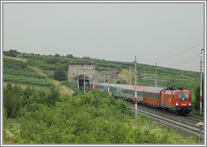 Es muss ja nicht immer Sonnenschein sein. Strmender Regen herrschte am Nachmittag des 3.8.2006. Es war auch das einzige Foto, dass ich an diesem Nachmittag gemacht habe. Es ist einfach zu umstndlich mit Regenschirm und Kamera in der Botanik zu stehen *g*. Das Foto zeigt 1116 215 mit dem EC 159  Zagreb  von Wien nach Zagreb bei der Ausfahrt des Busserltunneles zwischen Gumpoldskirchen und Pfaffsttten.