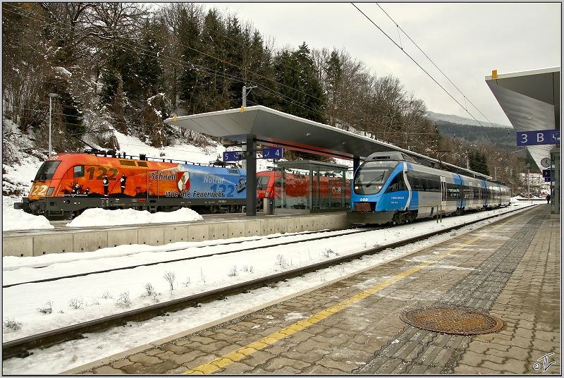 ET 4024 120  S-Bahn Steiermark  steht im Bahnhof Leoben, whrend E-Lok 1116 250  Feuerwehr  mit einem Erzzug fhrt. 
31.01.2009