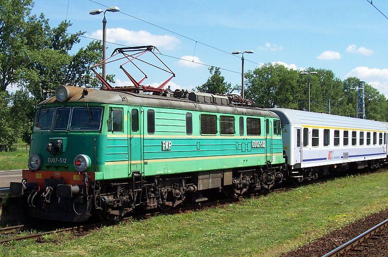EU07-512 mit grauen Zierstreifen und IC-Zug am 24.06.2005 in Warszawa Zachodnia (Warschau).