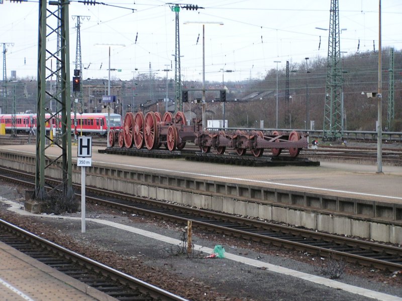 Fahrgestell der 18 602 als Denkmal auf einem Bahnsteig des Saarbr�cker Hbf. Die Lok wurde in den 1970er Jahren als Heizlok am alten BW Saarbr�cken (Geb�ude im Hintergrund) eingesetzt. Aufnahme vom 09.01.2005