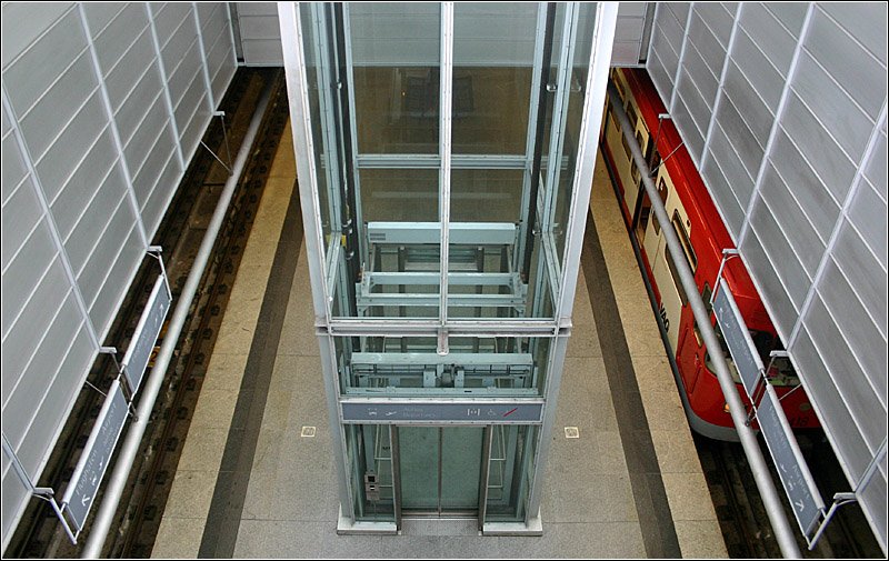 Flughafen, Linie U2 (1999) - 

Blick durch eine Deckenöffnung in den U-Bahnhof. Vorherrschende Materialien sind Metalprofile und Alu-Paneele. An der Oberfläche übedeckt ein Glasdach den Stationsbereich. 

Nürnberg, 05.03.2006 (M)