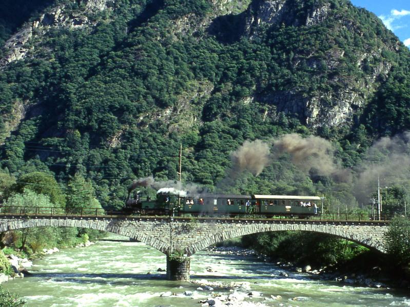 FM Dampfextrazug V3214 fr GRAUBNDEN TOURS von Castione-Arbedo nach Cama vom 29.08.1997 auf der Moesabrcke bei Roveredo mit Dampflok G 3/4 1 - B 2060 - A 1102. Hinweis: Die Stammnetzkompo verkehrte so nur von Castione-Arbedo bis Grono. In Grono wurde noch der B 21 angekuppelt. Wer die Fotostelle nicht kennt, hinter der Brcke befindet sich eine Autobahn - Spannbetonbrcke, die aus normaler Fotohhe strend sichtbar ist!