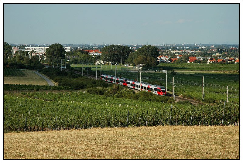 Fotowolke, oder Theaterbeleuchtung? Im Gegensatz zu dem gestern gezeigten Bild, gefllt mir hier diese Teilfotowolke sehr sehr gut, da sie eine eigenartige Stimmung erzeugt. S 8 von Wiener Neustadt nach Mdling, gebildet aus einem 4124er Tandem (Zweisystemtalent). Das wei ich deshalb, weil ich ca eine Stunde vorher damit in die andere Richtung gefahren bin. Aufnahme auf der Hhe des Nordportals des Busserltunnels mit Gumpoldskirchen im Hintergrund.