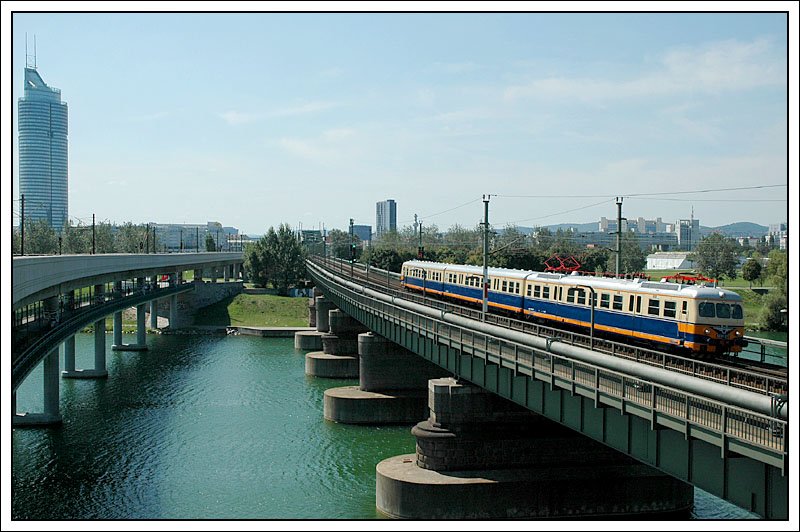 Fr eine Sonderfahrt am 18.8.2007 von Leopoldau nach Wolfsthal und wieder retour wurde ET 4030.210 von Wien Praterstern nach Leopoldau als Lp 32398 berstellt. Die Aufnahme entstand bei der Querung der Donau zw. Handelskai und Floridsdorf. Links am Bild ist der 171 Metern (202 m incl. der Turmspitze) hohe Millennium Tower zu sehen. Interessant die Daten der 15.000 m groen Verglasung. Die Einzelscheiben des dreiteiligen Verbundglases bestehen aus Floatglas mit einer Glasdicke von 34 mm. In gefhrdeten Teilbereichen wurde zum Schutz vor Durchbruch die Auenscheibe durch Verbundsicherheitsglas ersetzt. Erstmals kam in sterreich das rationelle, kostensparende  Stahlbundverfahren  zum Einsatz. Statt drei Wochen fr ein Gescho wurde beim Millenium Tower lediglich eine Woche fr zwei Stockwerke bentigt. 1999 war er fertig.
3.300 m Broflche bieten sich im 50geschoigen Gebude an. Weiters findet man darin einen Kindergarten, ein rztezentrum sowie 425 Wohnungen und ein Einkaufszentrum.
