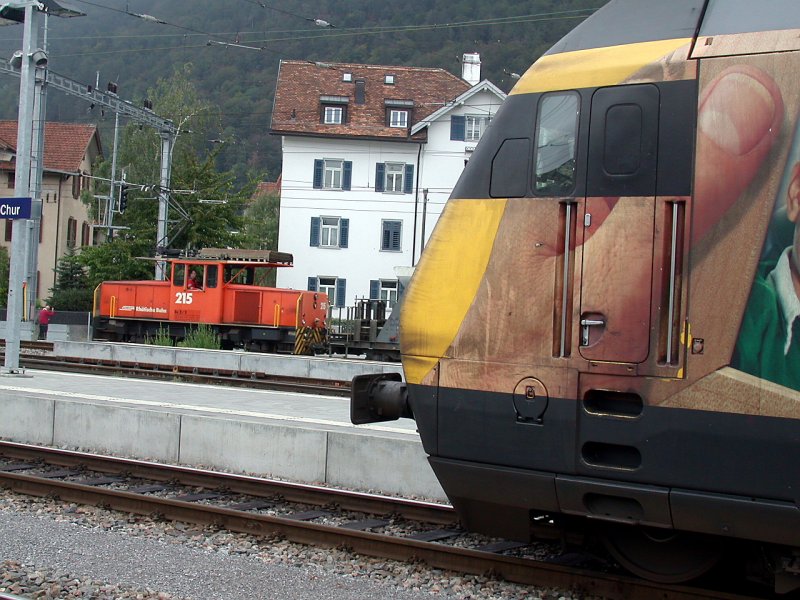 Ge 2/3 215 der RhB auf Rangierfahrt im Arosaareal des Bahnhofs Chur. Im Vordergrund ist eine SBB Re 460 mit Western Union Werbung sichtbar. (27.09.2006)
