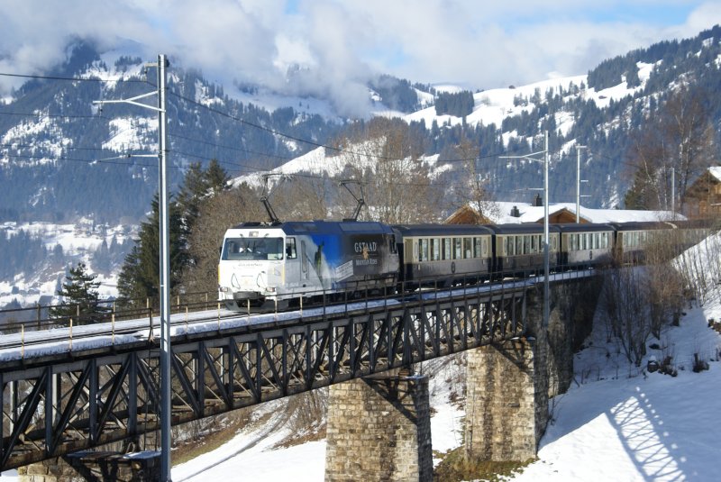 Ge 4/4 8001 mit Werbung fr Gstaad Mountain Rides nhert sich am 21.12.08 mit dem Golden Pass Classic Gstaad.