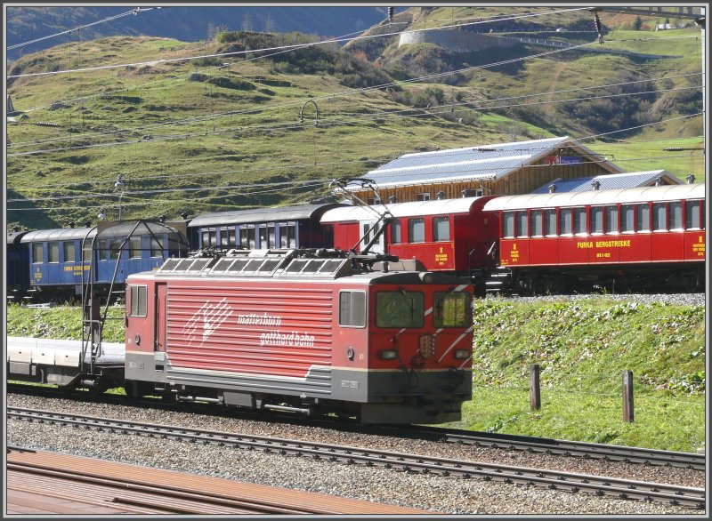 Ge 4/4 81  Wallis  schiebt den Autozug durch den Furkatunnel nach Oberwald, hier bei der Ausfahrt aus Realp. Dahinter ist das Stationsgebude der DFB und ein Teil ihres abgestellten Wagenparks zu sehen. Im Bild oben ist eine der unzhligen Kehren der im Moment noch geffneten Furkapassstrasse zu erkennen. (08.10.2007)