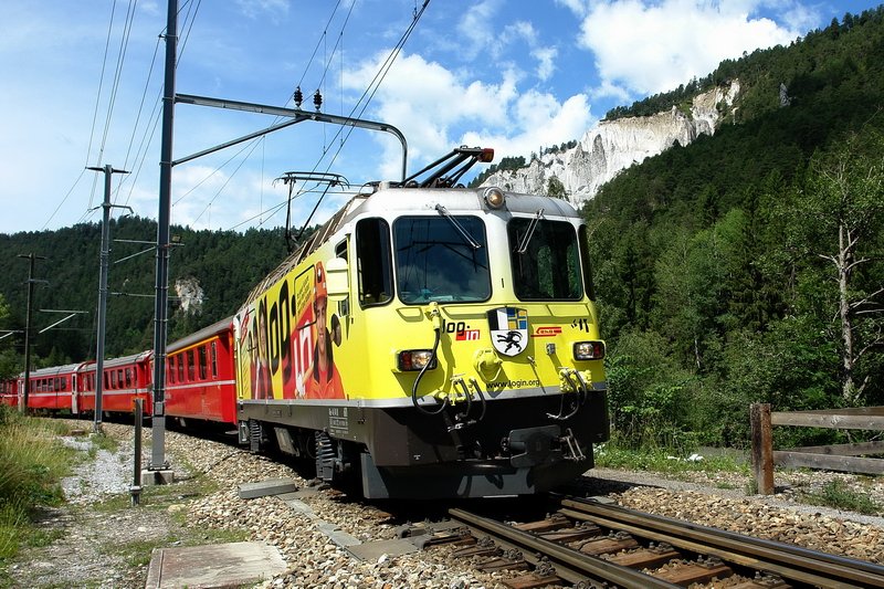 Ge 4/4 II 611  Landquart . Eine leuchtend gelbe Werbelok vor einem roten RegioExpress in der Rheinschlucht beim Bhf. Versam-Safien. Da freut man sich als Fotograf gleich doppelt, obwohl die Hitze einem etwas zusetzt. 30.6.2008