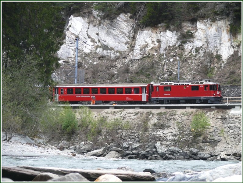 Ge 4/4 II 633  Zuoz  zieht den RE1241 dem Vorderrhein entlang nach Reichenau-Tamins. In der S-Kurve bei der Hochwassermarke wurden Geleise und Brckenbauwerke erneuert und ein Arbeiter ist noch mit letzten Umgebungsarbeiten beschftigt. (16.04.2009)