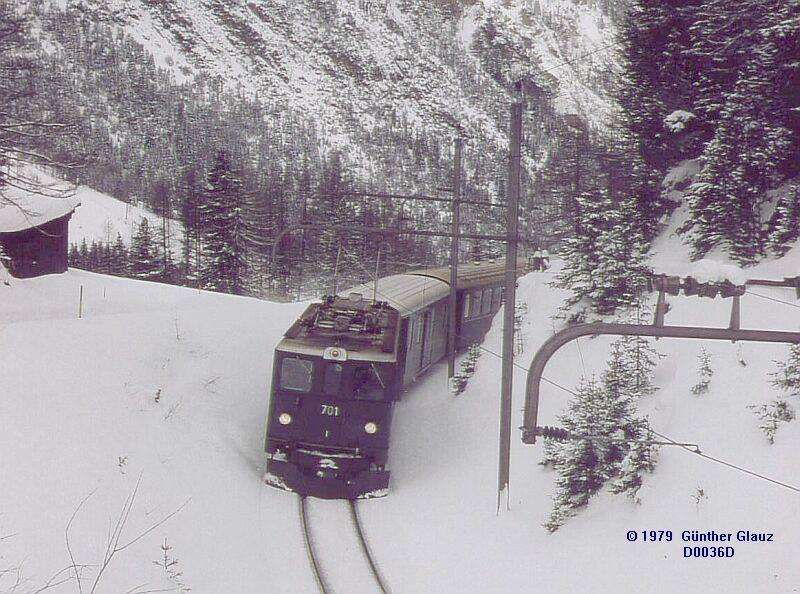 Ge 6/6 II 701 mit Reisezug vor der Albula-Straenbrcke bei Naz, nach dem Zwondra-Tunnel - Mrz 1979. Diese Lok hat eine andere Frontpartie wie die Loks Ge 6/6 II 703 bis 706, und zwar 3 statt 2 Fenster.
