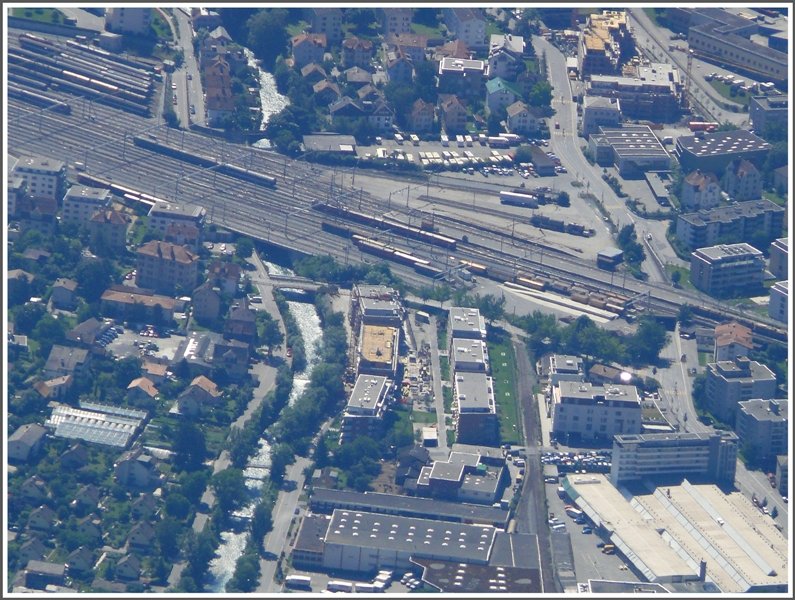 Gegen den oberen Bildrand befinden sich Abstellanlage und Freiverlad SBB, herwrts die Abstellanlage, Freiverlad RhB und Zufahrt mit Dreischienengleis ins Industriequartier. Die Plessur unter dem Bahnhof bringt trbes Schmelzwasser aus den Bergen rund um Arosa. (29.06.2008)