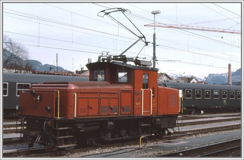 Gem 2/4 211 der RhB im Bahnhof Chur. Das Normalspurgleis mit den Belgischen Liegewagen gibts heute nicht mehr und das Kamin der ehemaligen Hauptwerksttte wird nchstens abgerissen. (Archiv 03/77)