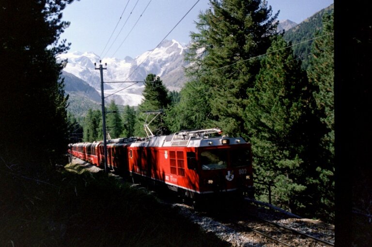 Gem 4/4 und ein ABe 4/4 mit Bernina-Express oberhalb der Station Morteratsch im August 2003.