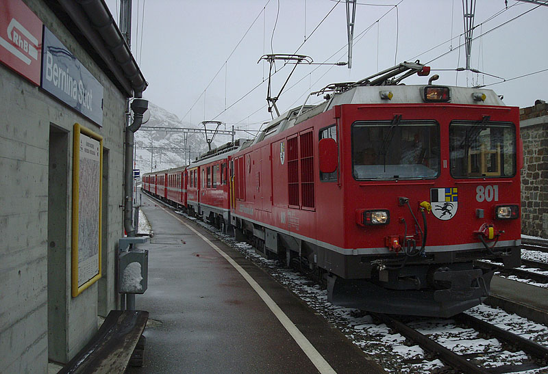 Gem 4/4 Nr. 801 und ABe 4/4 III Nr. 56 fahren bei garstigem Wetter mit rund 10 Min. Versptung in Bernina-Suot ein, 12. Okt. 2009, 13:58