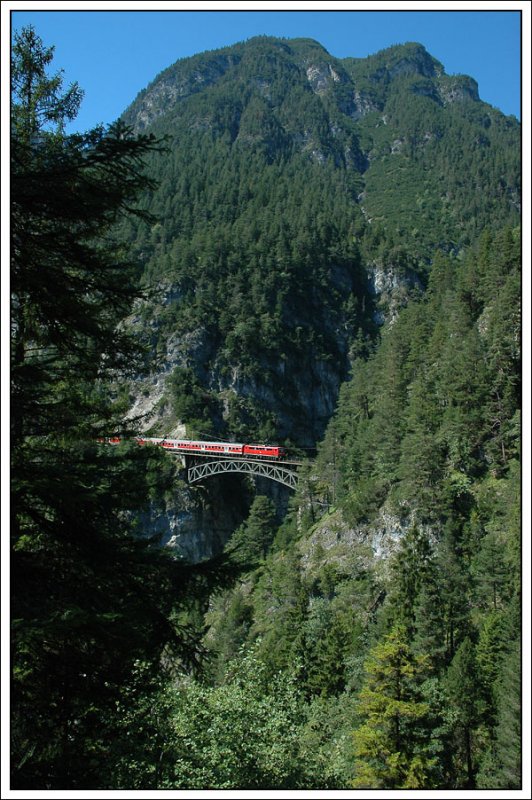 Genauso berhmt wie die Trisannabrcke ist die 66 Meter lange Brcke ber den Schlossbachgraben der Mittenwaldbahn (auch Karwendelbahn genant). Am Foto vom 26.7.2007  ist R 5420 von Innsbruck auf dem Weg nach Mnchen zu sehen welcher von einer DB 111 geschoben wird.