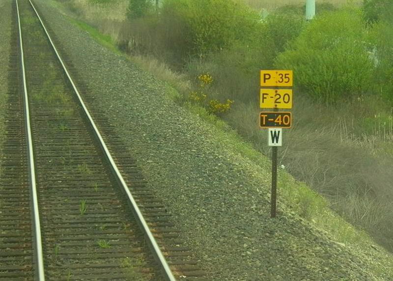 Geschwindigkeitstafel an der BNSF-Strecke Seattle - Everett. Die Buchstaben bedeuten: P = Passenger, F = Freight, T = Talgo. Das darunter angebrachte schwarze W auf weiem Grund ist eine Pfeiftafel (W = Whistle) fr einen folgenden Bahnbergang (Mai 2003).