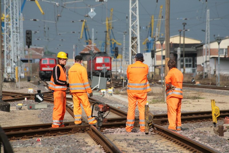 Gleisbauarbeiter im Bahnhof Wismar vor den Krananlagen des Seehafens. 31.03.2009