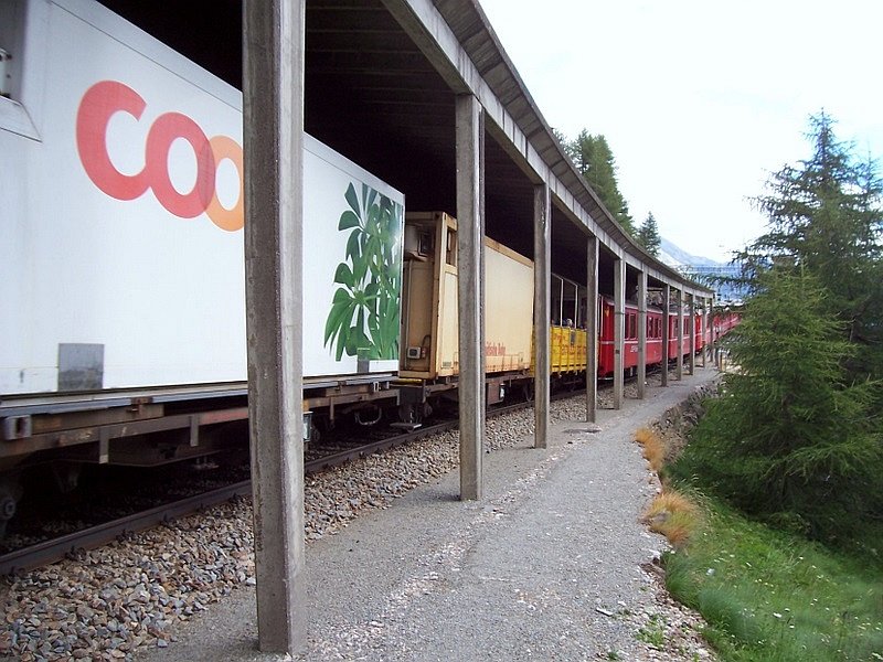  GmP  (Gterzug mit Personenbefrderung) fhrt am 11.07.2007 von Osprizia Bernina kommend in den Bahnhof Alp Grm ein. Die Aufnahme wurde von  erlaubten Gelnde  gemacht, an der Gallerie fhrt ein markierter Wandersteg zum Bahnhof entlang.