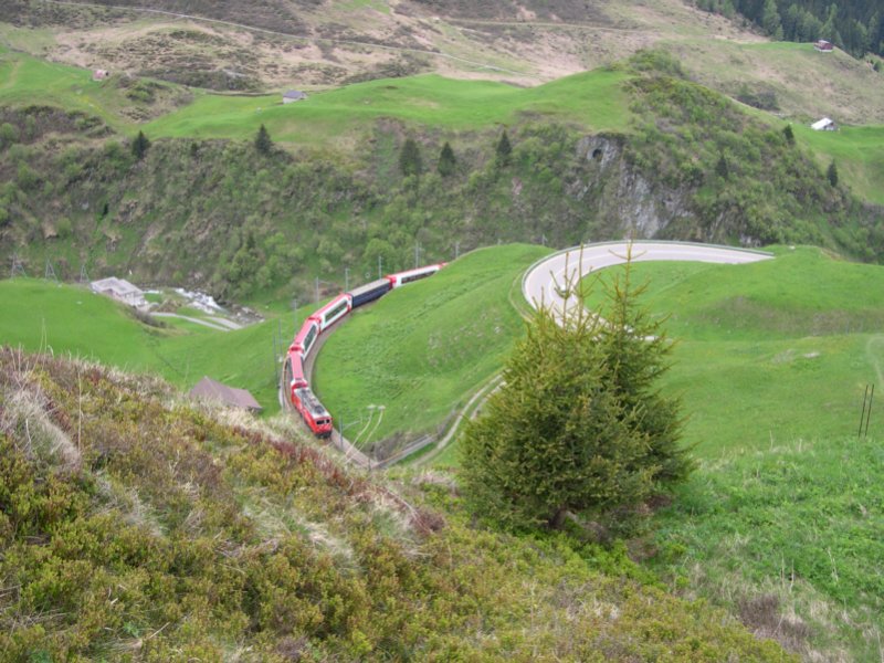 Gotthard 2008 - Mit D 908  Glacier-Express  schleicht am 24.05.2008 MGB HGe 4/4 107 bei Andermatt den Ntschen hinauf. Gleich verschwindet der Zug im 206m langen Butzen-Tunnel.